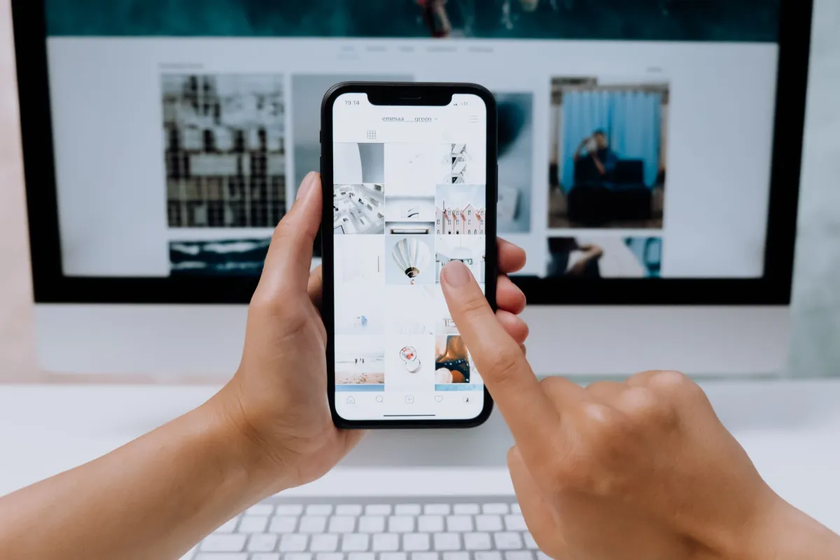Hands holding a smartphone while scrolling through a social media feed