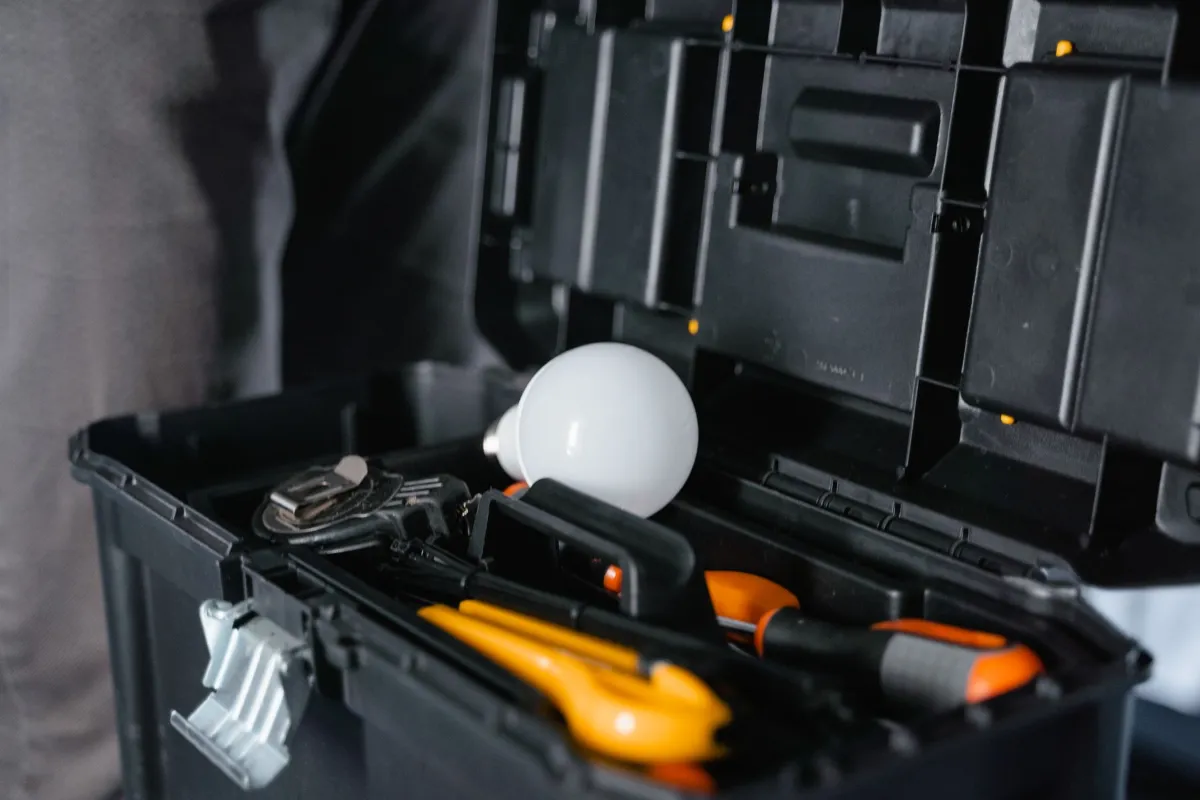 Open toolbox with hand tools and a light bulb, the kind of kit a service-area business takes to customers
